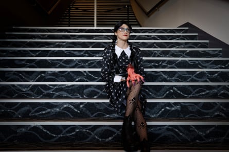 A woman in a black dress sitting on stairs