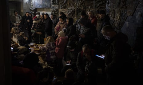 People gather in a basement, used as a bomb shelter, during an air raid in Lviv on Saturday.