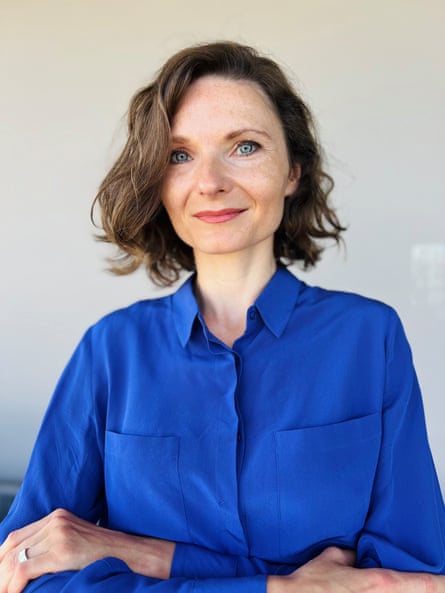 a woman in a blue shirt smiles