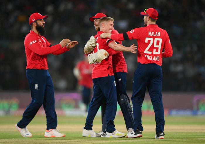 Wood is congratulated by teammates after taking the wicket of Nawaz .
