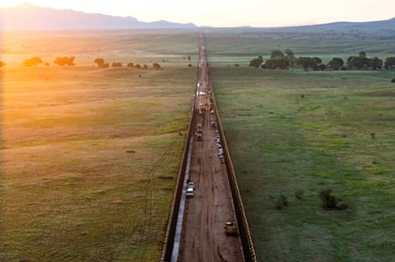 Cars driving along a border wall