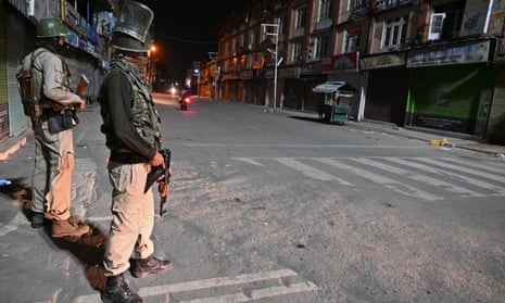 Indian paramilitary troopers stand guard at a roadblock in Srinagar, Kashmir.