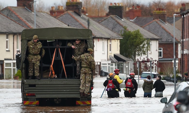 Members of the British army assist the emergency services in a flooded street in Carlisle.