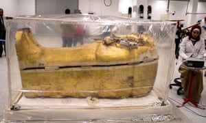 An archeologist works next to the gilded coffin of King Tutankhamun, which is undergoing restoration at the Grand Egyptian Museum in Giza, Egypt.