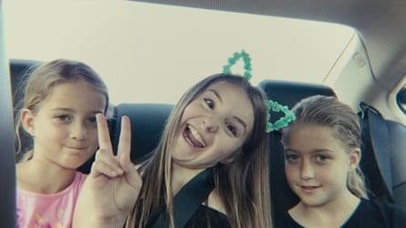 The three preteen girls sit in the back of a car; Piper Rockelle is in the centre, wearing bunny ears and making a peace sign