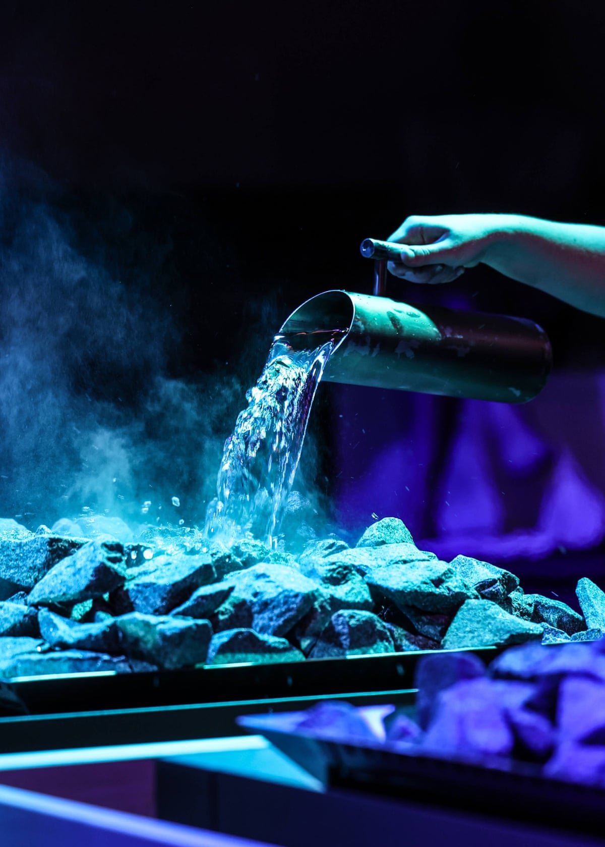 A jug of water is poured over hot stones.