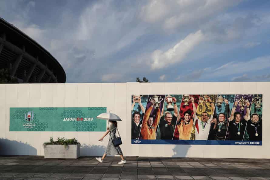 A woman walks past a billboard promoting the Rugby World Cup at the International Stadium Yokohama.