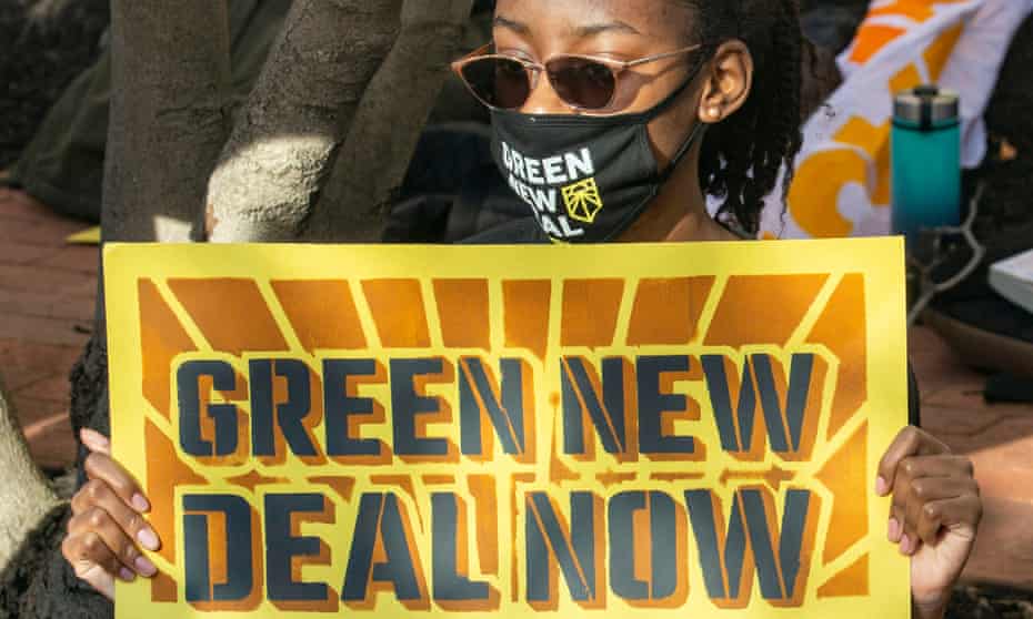 An activist holds a Green New Deal sign during a rally in Washington DC Thursday.