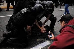A demonstrator is detained while another records on his phone