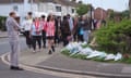 Members of the community visit floral tributes to Daniel Anjorin in a street in Hainault, London. 