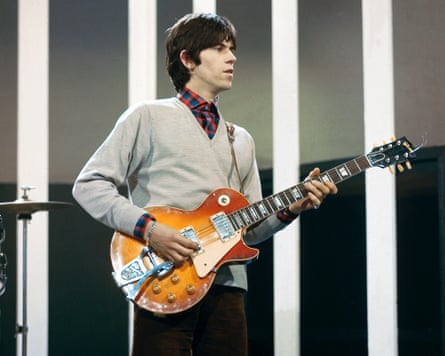 Keith Richards plays an orange Gibson Les Paul guitar before striped vertical panels