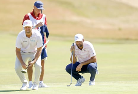 Wyndham Clark (left) and Scottie Scheffler line up their putts.
