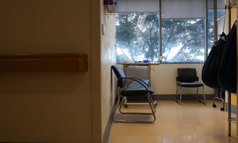 Empty chairs near a window looking out to trees, in a hospital waiting room