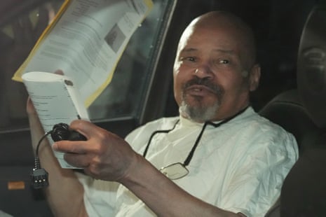 Douglas Stewart Carter reads a document while sitting in a car after his release