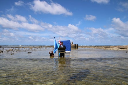 Simon Kofe, Tuvalu’s minister for justice, communication & foreign affairs, gives a statement to Cop26 while standing in the ocean