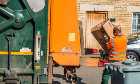 A council workman taking cardboard waste to the refuse lorry