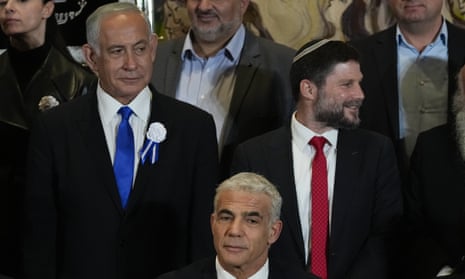 Likud chairman Benjamin Netanyahu, left, and Religious Zionism leader Bezalel Smotrich stand behind the Israeli PM Yair Lapid in the Knesset last month.