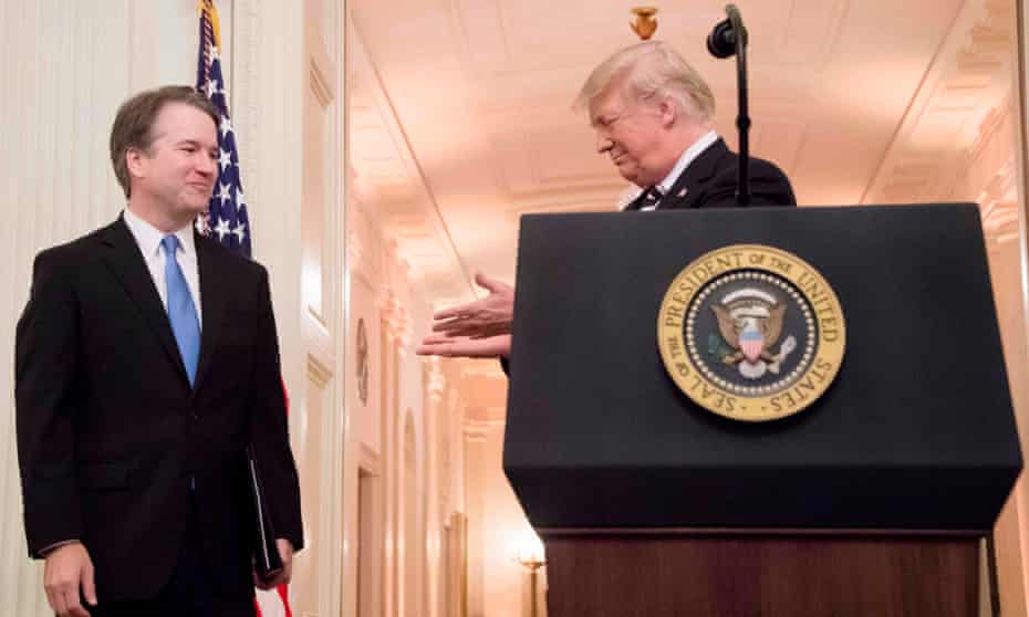 Donald Trump gestures to Brett Kavanaugh during the supreme court justice’s swearing-in at the White House.