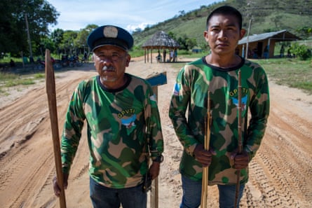Lauriano Afonso da Silva, a 61-year-old activist, with Jedeão Pereira Batista, 21, shows off the wooden spear he uses to guard his Indigenous community.