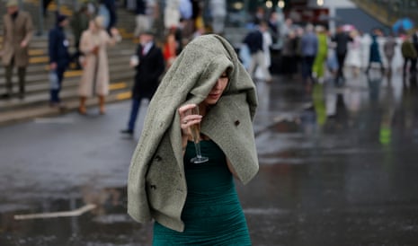A racegoer gets caught in the rain.