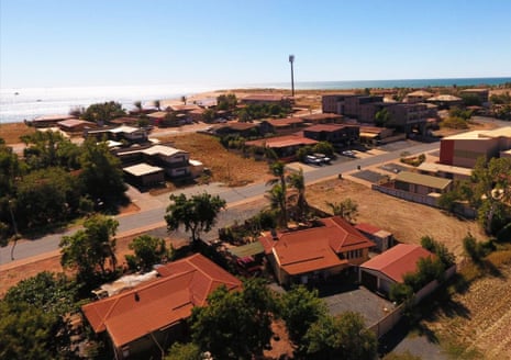 An aerial view of Port Hedland showing some residential rooftops with the ocean in the background