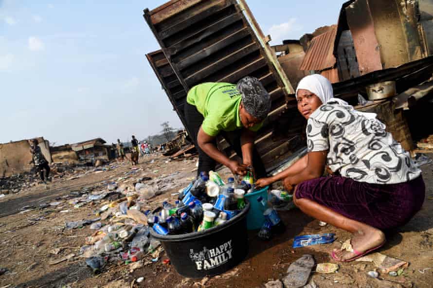 Women clean bottles recovered from shops burned down after Fulani-Yoruba clashes