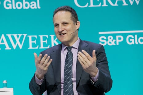 A man in a suit speaking on a stage.