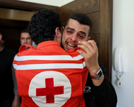 Коллеги фельдшера Красного Креста Хасана Бадави, погибшего в результате израильской забастовки в воскресенье, скорбят после его похорон в Бешамуне, Ливан.