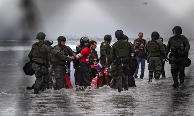 Activists are arrested as they demonstrate against US migration policies near the US-Mexico border fence.