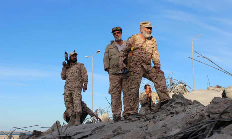 Libyan fighters stand atop the ruins of a house as they are close to securing last Isis holdouts in Sirte.