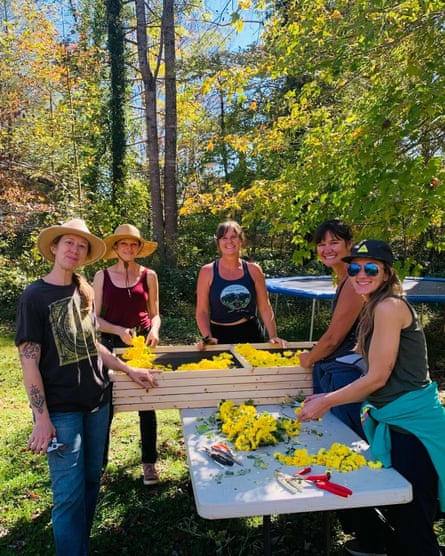 five women smiling for a photo outside