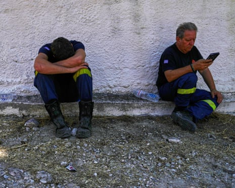 Firefighters take a rest a day after a wildfire in Peristeria village on the island of Salamina, west of Athens, Greece.