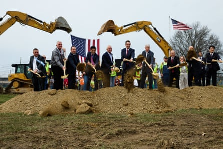 a line of mine break ground with shovels on a construction site