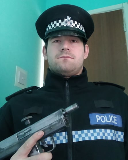 Reed Wischhusen in police uniform holding a gun