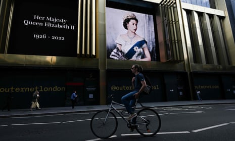 Pedestrians walk past a portrait of Queen Elizabeth II in London on 11 September 2022