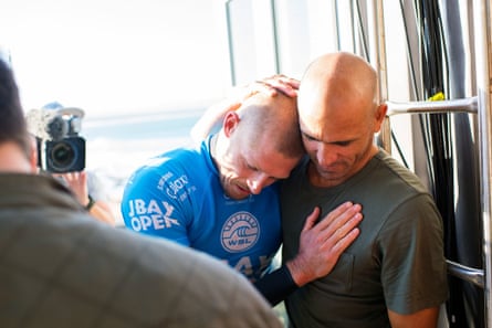 Mick Fanning (left) hugs US surfer Kelly Slater after being attacked by a shark.