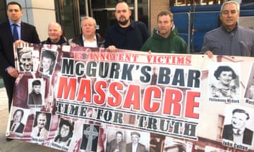 Victims' relatives hold a banner with photos of those killed on it and the words: Innocent victims, McGurk's bar massacre, time for truth.