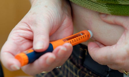 A patient injects herself with an insulin pen.