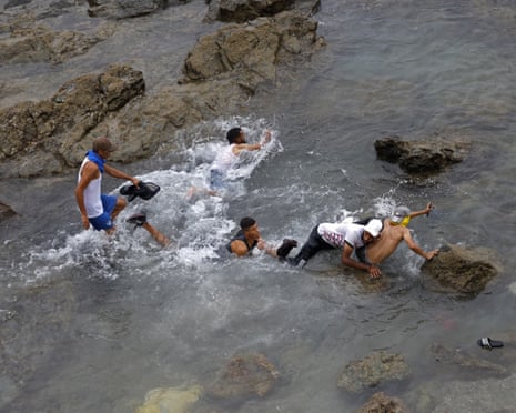 People try to swim through the waters close to the fence near Fnideq, on the Morocco-Spain border.