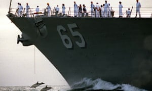 Dolphins in front of US Navy ship Benfold. Marine life will now be protected from Navy sonar.