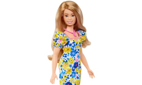 Barbie doll with Down's syndrome, wearing pink necklace and blue, yellow and white dress.