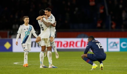 Paris FC players celebrate in front of a dejected Ousmane Dembélé.