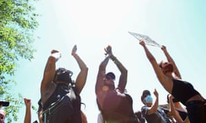 People raise their hands and clap during a protest against the death of Elijah McClain and police injustice in Aurora, Colorado, on 27 June.