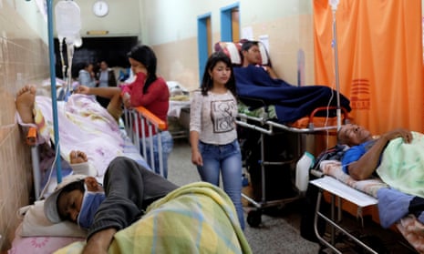 Patients lie on beds in an aisle of the emergency room at the University Hospital in Merida, Venezuela
