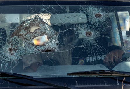 A police officer sits inside his bullet-ridden vehicle in Port-au-Prince.