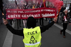 Protesters in Nantes with a banner reading ‘49.3 or not, let’s keep fighting, general strike’ and a demonstrator in a vest also referring to article 49.3 of the French constitution, which is allowing the government to push through the changes