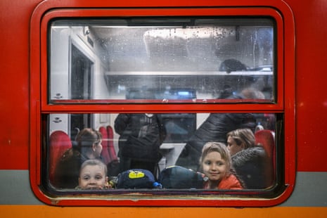 Children who fled the war in Ukraine look through a window as they wait for the departure of a humanitarian train to relocate refugees to Berlin on 13 March in Krakow, Poland.