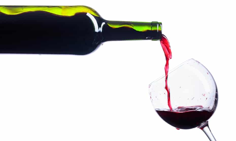 Pouring red wine from bottle to glass