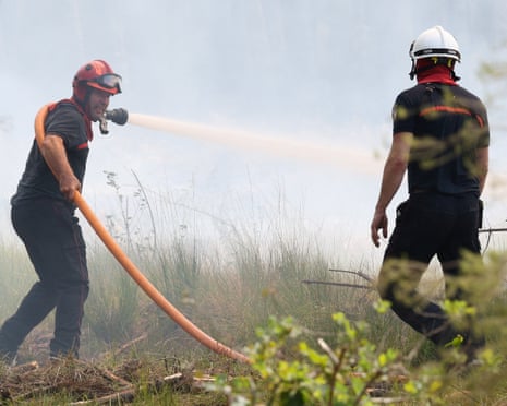 Firefighters work to extinguish a fire burning in Le Temple, Gironde department, amid drought conditions following a heatwave and water shortages across much of France.