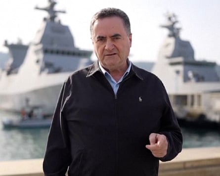 Israel Katz standing in front of battle ships pointint towards the camera.